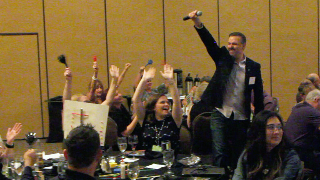 Kid Corona performing as a San Diego DJ and corporate game show host, engaging guests with high-energy trivia and interactive entertainment at an event.